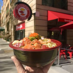 Hand holding up Poke Bowl in front of Spoonfish Poke