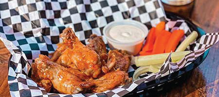 Plate of wings, celery, carrots, and ranch from Food & Beverages Restaurant