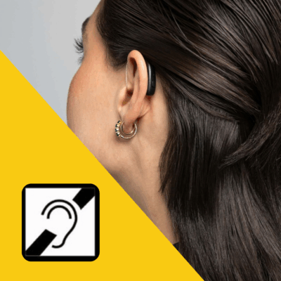 A closeup of a woman turned away, on her ear is an assistive hearing device. In the left corner is the assistive listening pictogram