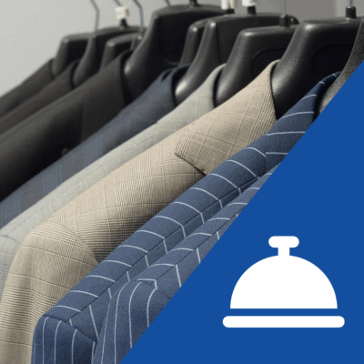 A closeup of a rack of suit jackets. In the right corner is an icon of a bell