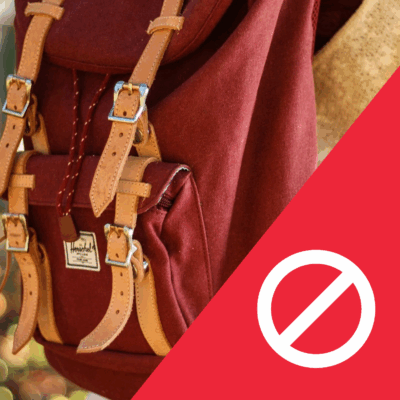 A large red backback worn on someone's back. In the right corner is the prohibition symbol