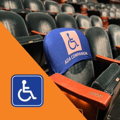 rows of seats in the hammer theatre auditorium, focused on a ADA Companion designated seat. In the left corner is handicap pictogram